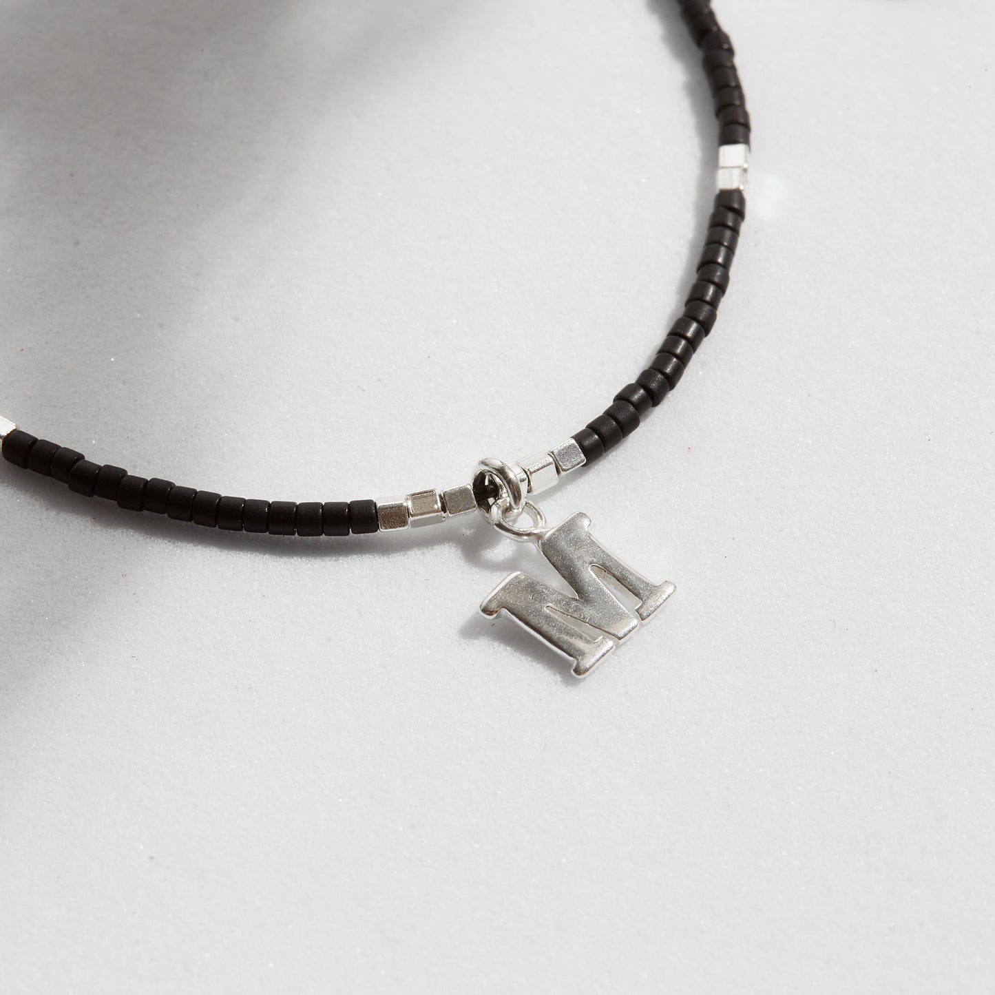 PULSERA NEGRA AJUSTABLE INICIAL FORMA