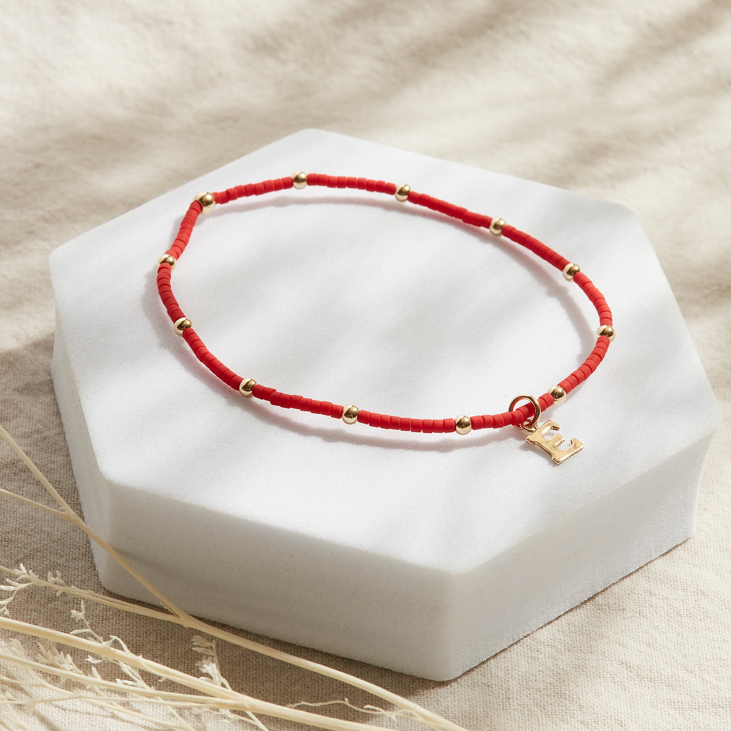 PULSERA ROJA ELASTICADA GOLDFILLED CON INICIAL